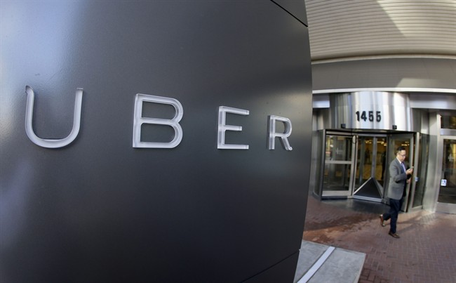 In this photo taken Tuesday, Dec. 16, 2014, a man leaves the headquarters of Uber in San Francisco. Uber could be expanding it's carpooling service into Toronto.