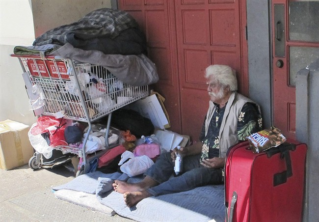 In this photo from June 2015 a homeless man sits on a sidewalk in Chinatown in Honolulu, Hawaii. 