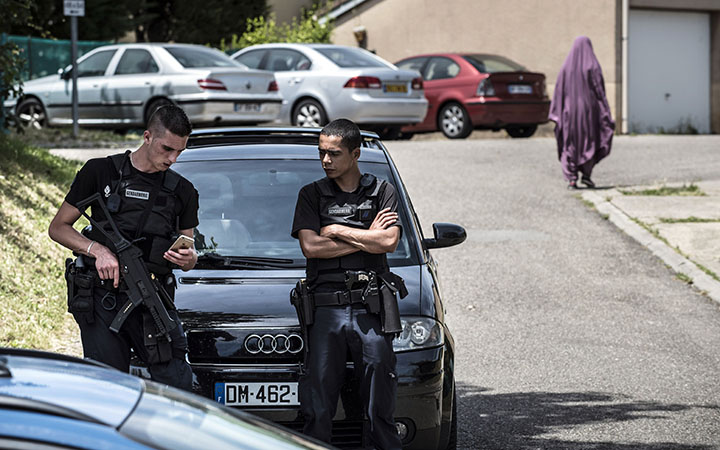 French gendarmes stand guard at the entrance of a street where criminal investigation police carried out a search at the home of a suspect in the Moines neighborhood of Saint-Quentin-Fallavier, near Lyon, France, on June 26, 2015.