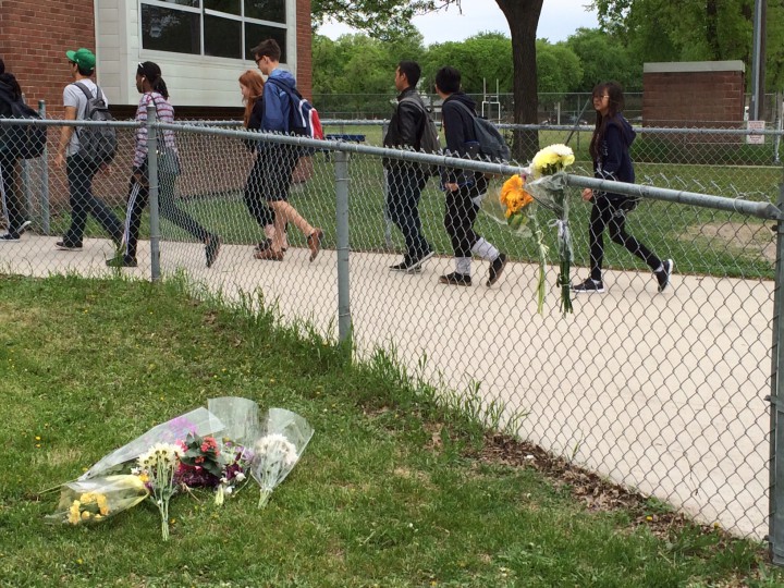 Students at Kelvin High School walk past a memorial Wednesday set up for Brett Bourne, 17.  Bourne was stabbed to death Tuesday.