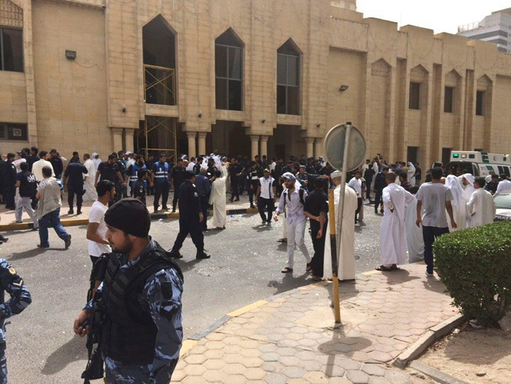 Security forces, officials and civilians gather outside of the Imam Sadiq Mosque after a deadly blast struck after Friday prayers in Kuwait City, Kuwait, Friday, June 26, 2015. 