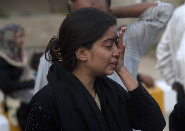 A Pakistani woman cries as her father suffers from heatstroke in Karachi, Pakistan, Tuesday, June 23, 2015. 