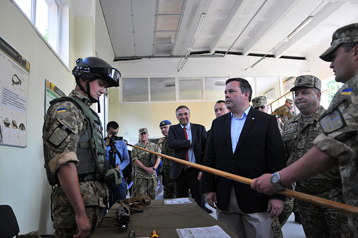 Ukrainian Defence Minister Stepan Poltorak, 2nd right, and Canadian Defence Minister Jason Kenney, centre, inspect the International Center for Peacemaking in the Lviv region, western Ukraine, Saturday, June 27, 2015. 