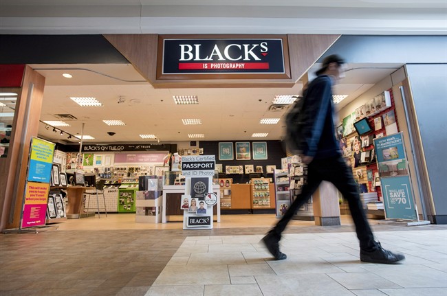 A man walks past a Blacks photo store in Ottawa.