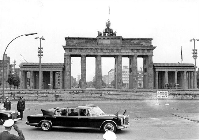A May 27, 1965 file photo of Queen Elizabeth II and Prince Philip being driven in a Mercedes 600 as they pass the Brandenburg Gate during their first visit to Berlin. 