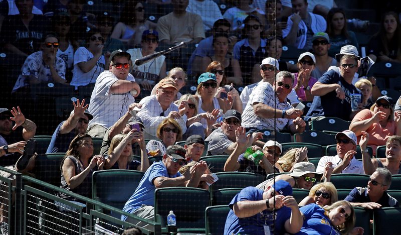 Fans duck as a bat from Seattle Mariners’ Rickie Weeks flies into the stands behind home plate in the eighth inning of a baseball game against the Tampa Bay Rays Sunday, June 7, 2015, in Seattle. No one was injured.