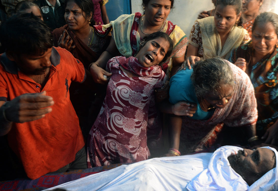 An Indian woman cries next to the body of a victim of toxic home-made liquor consumption, in Mumbai.