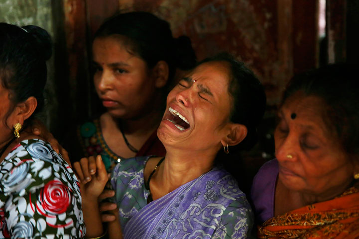 A relative one among the dozens who died after drinking tainted liquor cries during a funeral in Mumbai, India, Sunday, June 21, 2015.