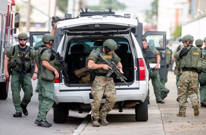 Law enforcement search in the St. Roch neighborhood for a man wanted in the fatal shooting of a New Orleans Police officer Saturday, June 20, 2015, in New Orleans.