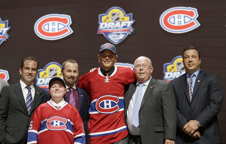 Noah Juulsen, center, poses with Montreal Canadiens executives after being chosen 26th overall by the Canadiens, during the first round of the NHL hockey draft, Friday, June 26, 2015 in Sunrise, Fla. 