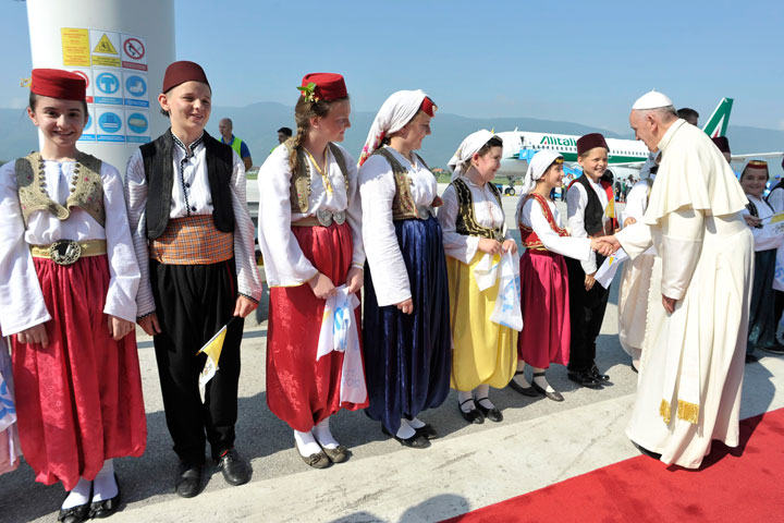 Pope Francis greets people wearing traditional costumes at the Sarajevo aiport, Bosnia-Herzegovina, Saturday, June 6, 2015. 