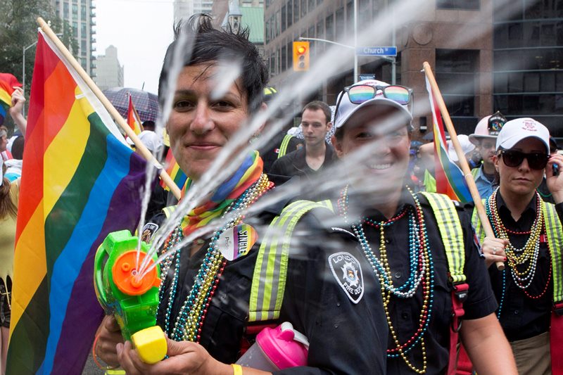 A participant fires a water gun as she walks the route during Toronto's Pride Parade on Sunday, June 28, 2015. 