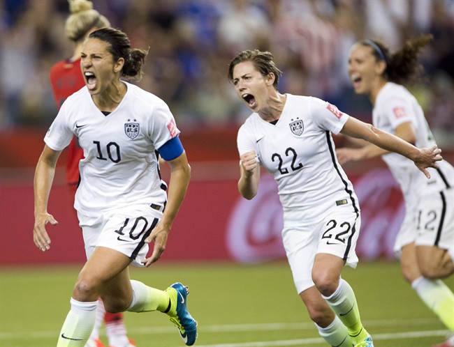 Carli Lloyd (10) reacts after scoring on a penalty kick against Germany as Meghan Klingenberg (22) joins in during second half Women's World Cup semi-final soccer on June 30, 2015.