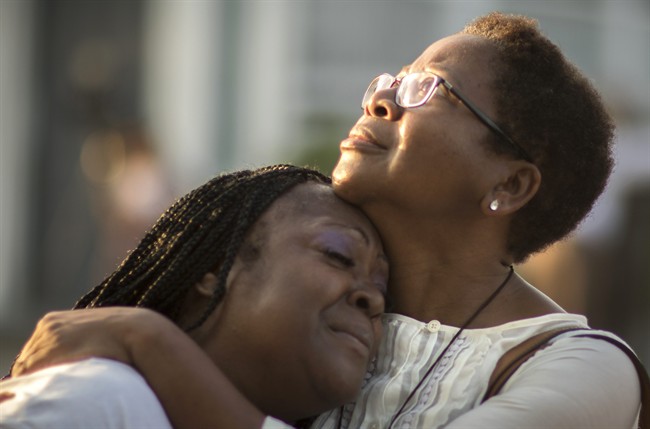 Gillettie Bennett, right, comforts Clarissa Jackson, left, Sunday, June 21, 2015, while she waits in line for Emanuel AME Church's first worship service since nine people were fatally shot at the church during a Bible study group, in Charleston, S.C.