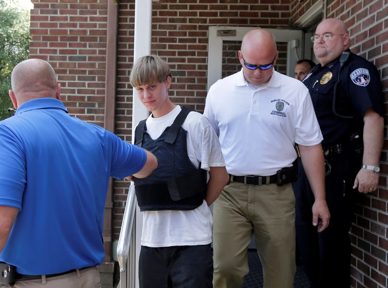 Charleston, S.C., shooting suspect Dylann Storm Roof, center, is escorted from the Shelby Police Department in Shelby, N.C., Thursday, June 18, 2015. Roof is a suspect in the shooting of several people Wednesday night at the historic The Emanuel African Methodist Episcopal Church in Charleston, S.C. 