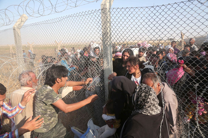 A group of Syrians cross the Turkey - Syrian border to take shelter in Turkey on June 14, 2015 in Sanliurfa's Akcakale district, Turkey.