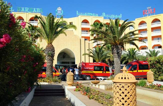 Injured people are treated near the area where an attack took place in Sousse, Tunisia, Friday June 26, 2015. A young man unfurled an umbrella and pulled out a Kalashnikov, opening fire on European sunbathers in an attack that killed 38 people at a Tunisian beach resort .