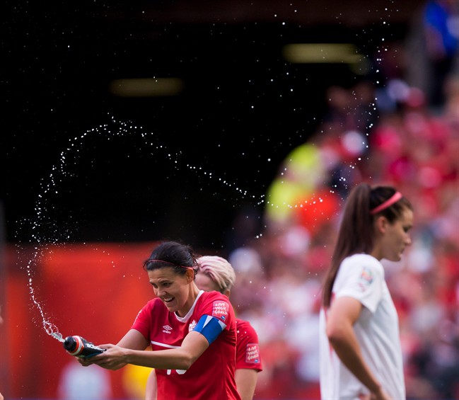 Canada's Christine Sinclair, left, sprays water in celebration as Switzerland's Rahel Kiwic, right, leaves the field after Canada defeated Switzerland 1-0 in the FIFA Women's World Cup round of 16 soccer action in Vancouver, B.C., on Sunday, June 21, 2015. THE CANADIAN PRESS/Darryl Dyck.