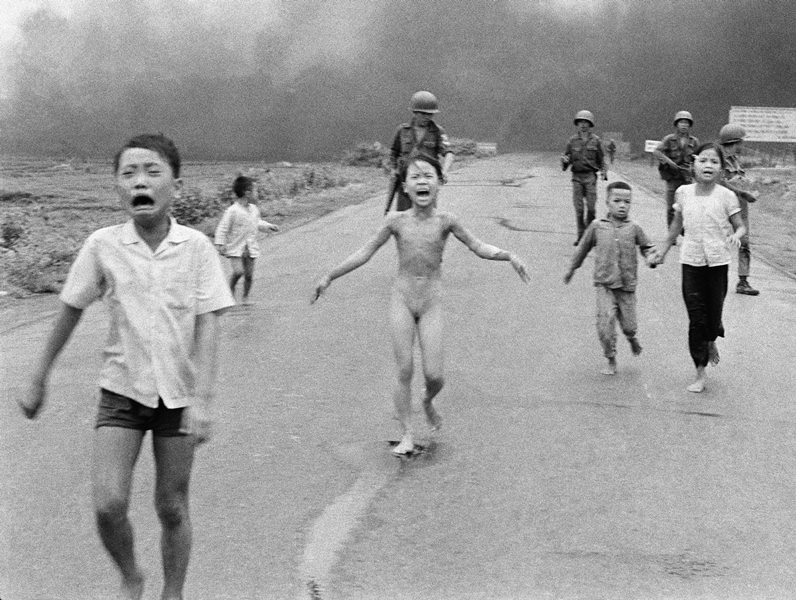 In this June 8, 1972, file photo taken by Huynh Cong “Nick” Ut, South Vietnamese forces follow behind terrified children, including 9-year-old Kim Phuc, center, as they run down Route 1 near Trang Bang after an aerial napalm attack on suspected Viet Cong hiding places. 
