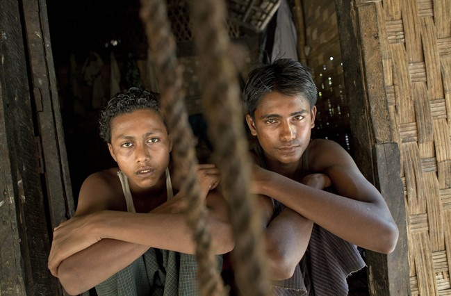 In this Monday, May 11, 2015 photo, 17-year-old Noor Alam, right, and 16-year-old Sadik Hussein squat together hours after escaping from a human-trafficking boat at Thetkabyin village, north of Sittwe in the western state of Rakhine, Myanmar. On Friday May 29, American actor Matt Dillon met with Noor Alam, putting a rare star-powered spotlight on Myanmar's long-persecuted Rohingya Muslims. Dillon visited a hot, squalid camp for tens of thousands displaced by violence and a port that has served as one of the main launching pads for their exodus by sea. (AP Photo/Gemunu Amarasinghe).