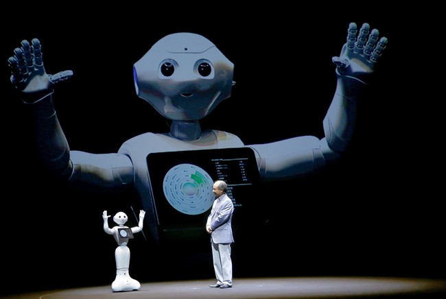 SoftBank Corp CEO Masayoshi Son speaks with the company's robot Pepper during a press conference.