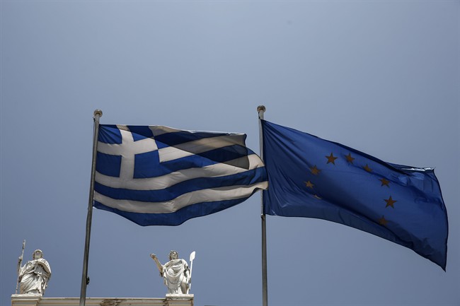A Greek and a European Union flags flutter in front of statues of goddess Athena, left, and Nautilia, in front of Benaki museum in Athens, Greece, on Wednesday, June 17, 2015. 