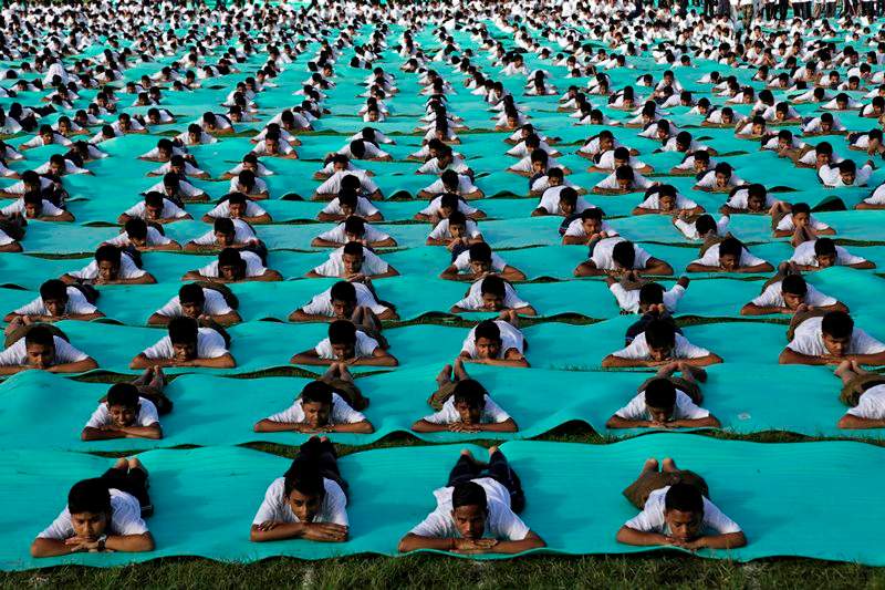 ndian school children perform yoga in an open field as they mark International Yoga Day in Kolkata, India, Sunday, June 21, 2015. Millions of yoga enthusiasts across the world bent and twisted their bodies in complex postures Sunday to mark International Yoga Day. 