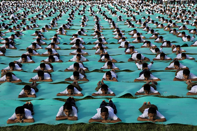 ndian school children perform yoga in an open field as they mark International Yoga Day in Kolkata, India, Sunday, June 21, 2015. Millions of yoga enthusiasts across the world bent and twisted their bodies in complex postures Sunday to mark International Yoga Day. 