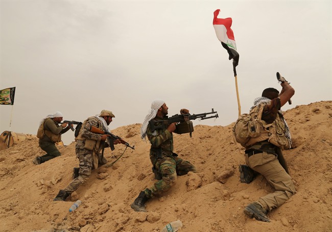 Fighters from Badr Brigades Shiite militia clash with Islamic State group militants at the front line on the outskirts of Fallujah, Anbar province, Iraq, Monday, June 1, 2015.