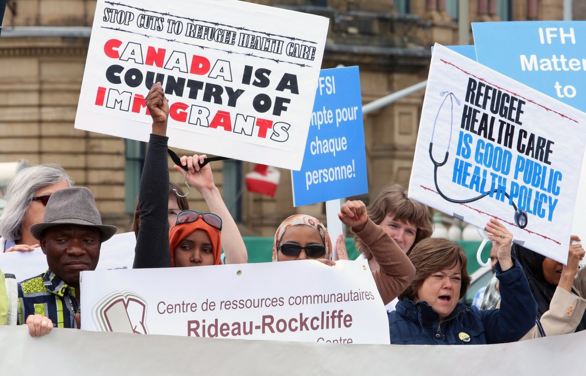 People protesting federal government cuts to refugee health services protest on Parliament Hill in Ottawa, Monday, June 17, 2013. 