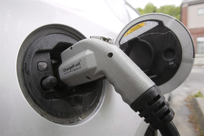 An electric vehicle is shown attached to a charging station on Tuesday, June 18, 2013 in Montpelier, Vt.