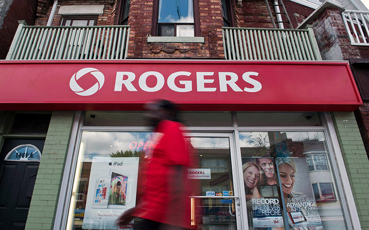 A man walks by a Rogers store in Toronto.