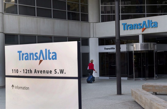 A woman walks towards the entrance of the TransAlta headquarters building in Calgary, on Tuesday, April 29, 2014.