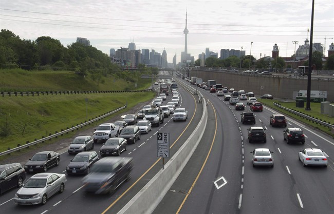 Vehicles travel along the nearly-empty Pan Am high-occupancy vehicle lanes as morning rush hour traffic crawls in Toronto on Monday, June 29, 2015.