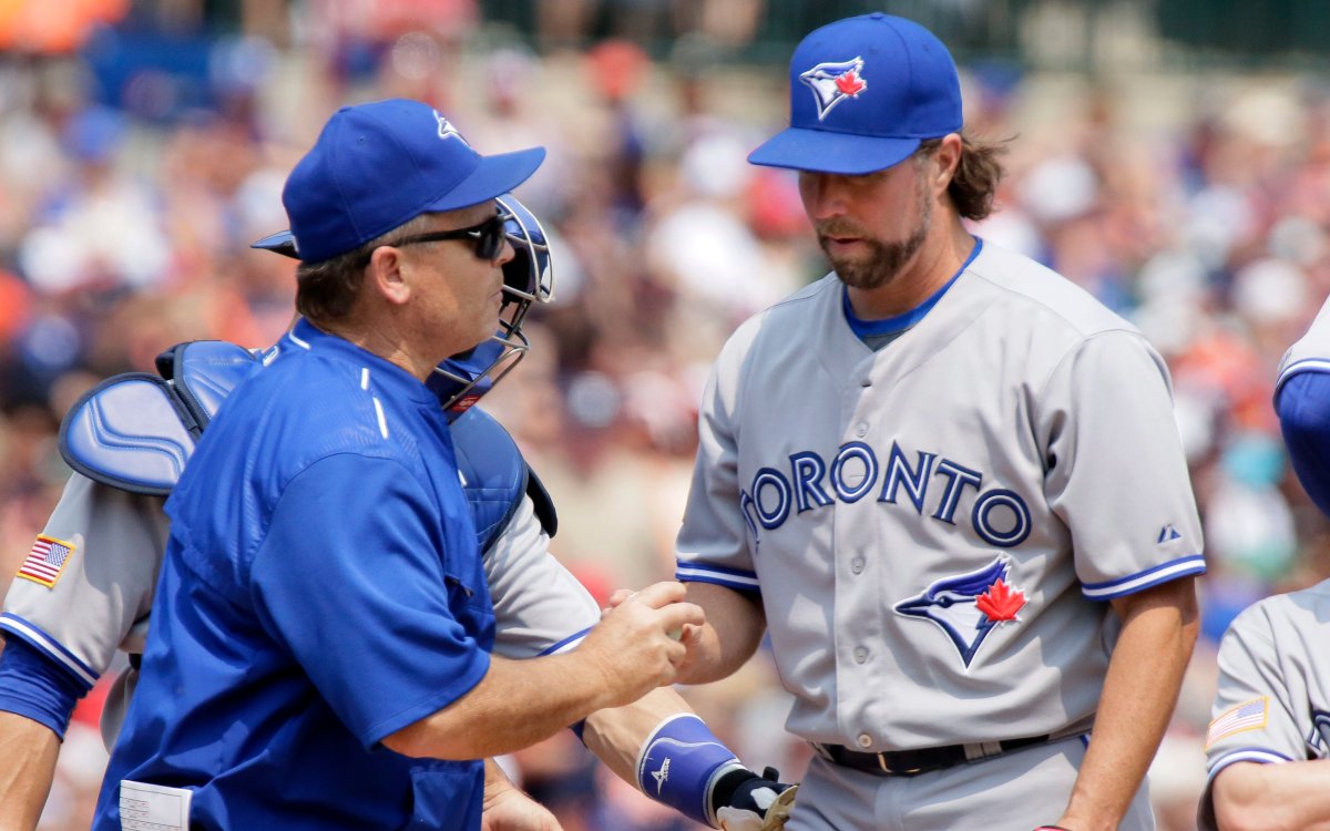 Toronto Blue Jays' R.A. Dickey, right, is pulled by manager John Gibbons, front left, during the sixth inning of a baseball game Saturday, July 4, 2015, in Detroit.
