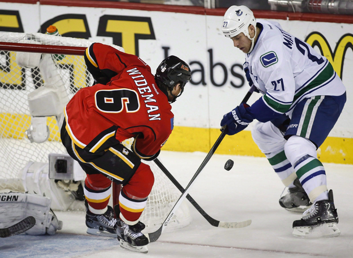 Vancouver Canucks Shawn Matthias, right, tries to get the puck past Calgary Flames Dennis Wideman during first period NHL first round game six playoff hockey action in Calgary, Saturday, April 25, 2015. The Toronto Maple Leafs signed centre Matthias to a one-year contract Monday.