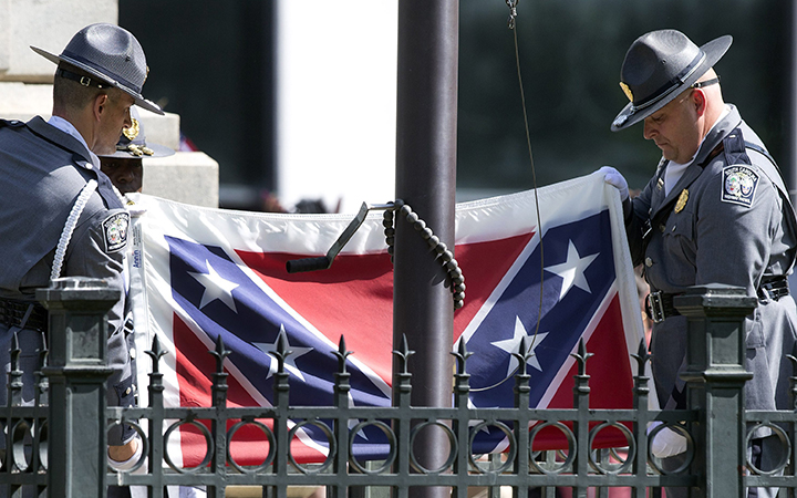 An honor guard from the South Carolina Highway patrol lowers the Confederate battle flag as it is removed from the Capitol grounds Friday, July 10, 2015, in Columbia, S.C.