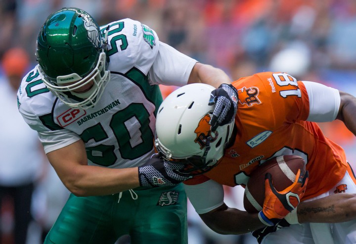 Saskatchewan Roughriders' Jake Doughty, left, grabs B.C. Lions' Cameron Morrah as he carries the ball during the first half of a CFL football game in Vancouver, B.C., on Friday July 10, 2015.