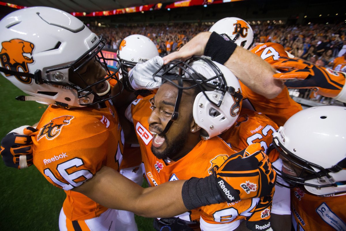B.C. Lions' Bryan Burnham, left, and Emmanuel Arceneaux, centre, celebrate Arceneaux's winning touchdown during overtime CFL football action against the Saskatchewan Roughriders in Vancouver, B.C., on Friday July 10, 2015. 