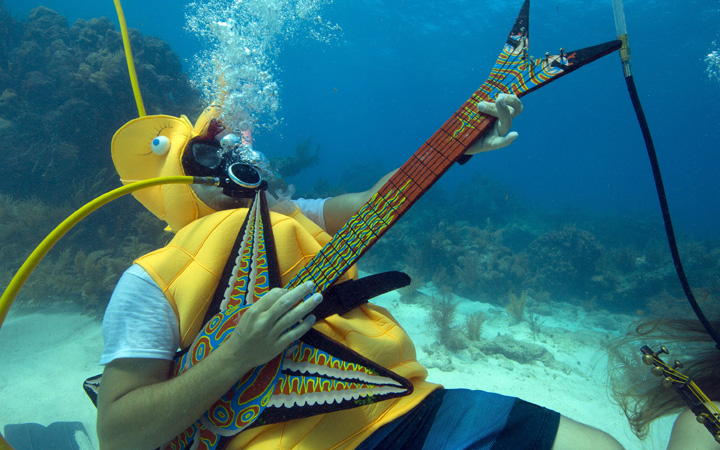 Jeff Wright, costumed as a seahorse, rocks with a fake guitar, Saturday, July 11, 2015, during the Underwater Music Festival in the Florida Keys National Marine Sanctuary off Big Pine Key, Fla.