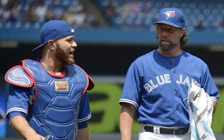 Toronto Blue Jays R.A. Dickey walks from the bullpen with catcher Russell Martin before their MLB baseball game against the Tampa Bay Rays Saturday, July 18, 2015 in Toronto.