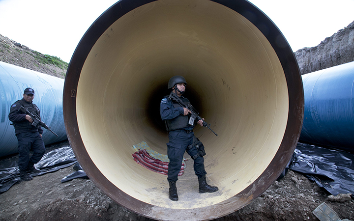 Mexican Federal Police guard a drainage pipe outside of the Altiplano maximum security prison in Almoloya, west of Mexico City. Mexico's most powerful drug lord, Joaquin "El Chapo" Guzman, escaped from a maximum security prison through a tunnel that opened into the shower area of his cell.