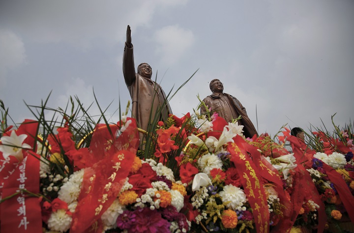 Bronze statues of the late leaders Kim Il Sung, left, and Kim Jong Il tower over flower offerings at Munsu Hill, Monday, July 27, 2015, in Pyongyang, North Korea. North Koreans gathered to offer flowers and pay their respects to their late leaders as part of celebrations for the 62nd anniversary of the armistice that ended the Korean War. (AP Photo/Wong Maye-E).