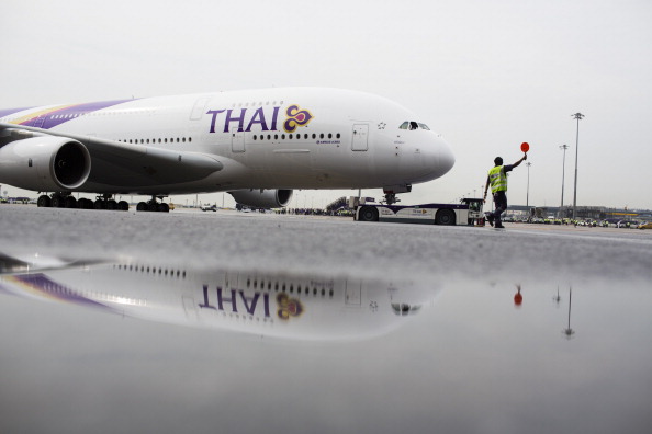 A Thai Airways International Pcl Airbus SAS A380-800 aircraft is reflected in a puddle on arrival at Suvarnabhumi Airport in Bangkok, Thailand, on Saturday, Sept. 29, 2012. 