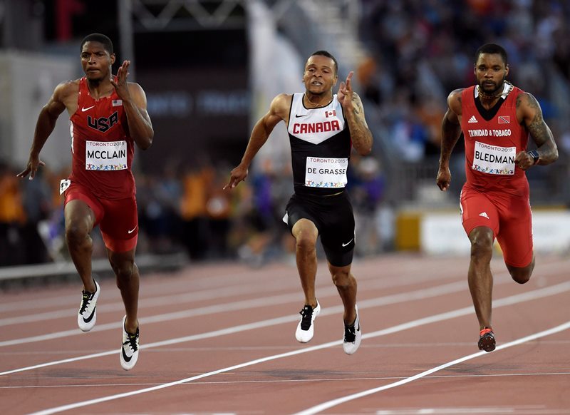 Andre De Grasse, of Canada, centre, wins gold medal in the men's 100m final during the athletics competition at the 2015 Pan Am Games in Toronto on Wednesday, July 22, 2015. 