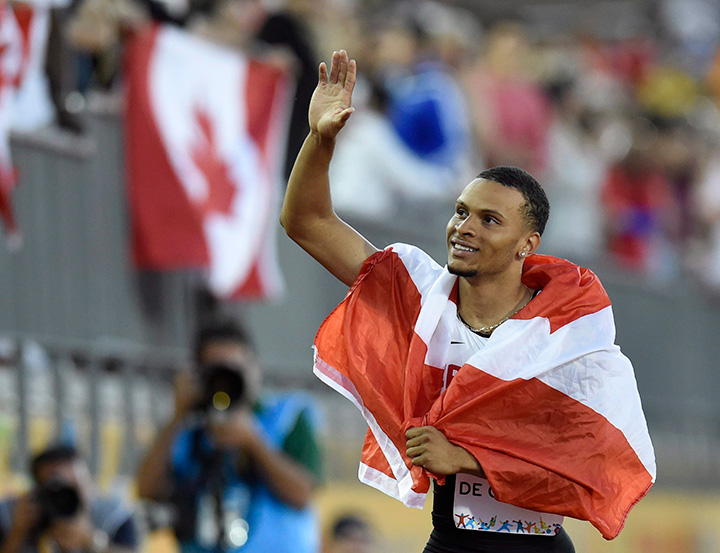 Canada’s Andre De Grasse holds a flag after winning gold in the men's 100m final at the 2015 Pan Am Games in Toronto on Wednesday, July 22, 2015. 