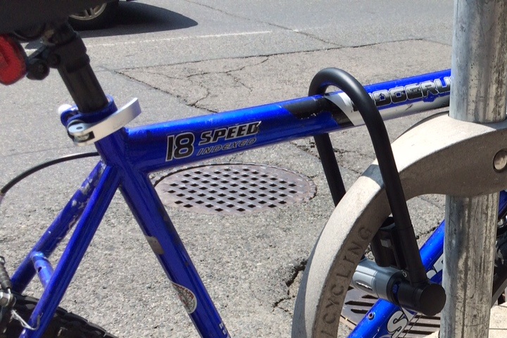 A bike is seen attached to a new-style ring-and-post  bike locking device.