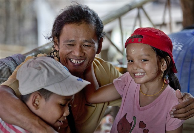 Myint Naing, center, hugs his niece Kyi Wai Hnin, right, and nephew Kyaw Min Tun