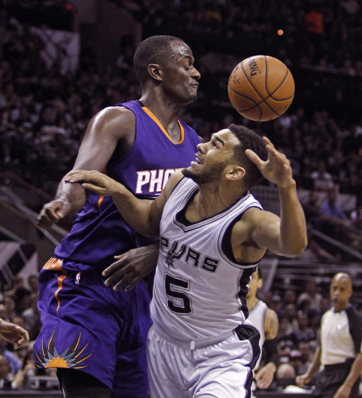 Former San Antonio Spurs' guard Cory Joseph, right, loses the ball against Phoenix Suns' Earl Barron, left, during the first quarter of an NBA basketball game, Sunday, April 12, 2015, in San Antonio. The Pickering, Ont., native has agreed to a contract with the Toronto Raptors.  