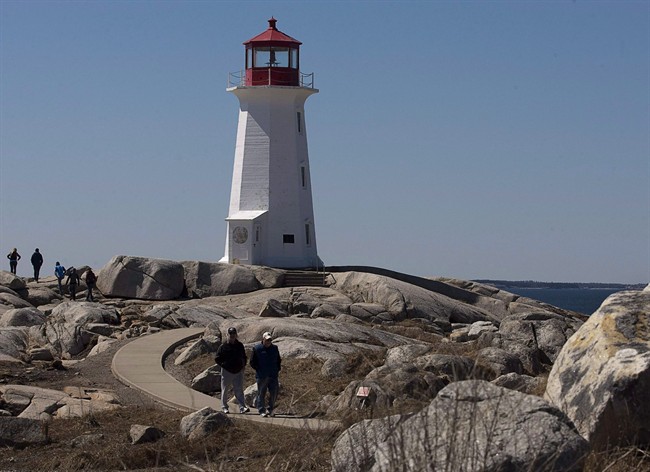 File - Tourists vist the lighthouse at Peggy's Cove, N.S.
